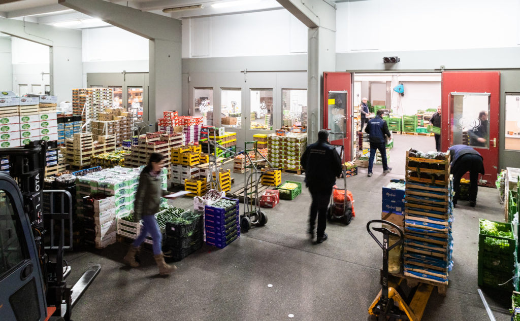 Personen beim Umladen von Obstkisten