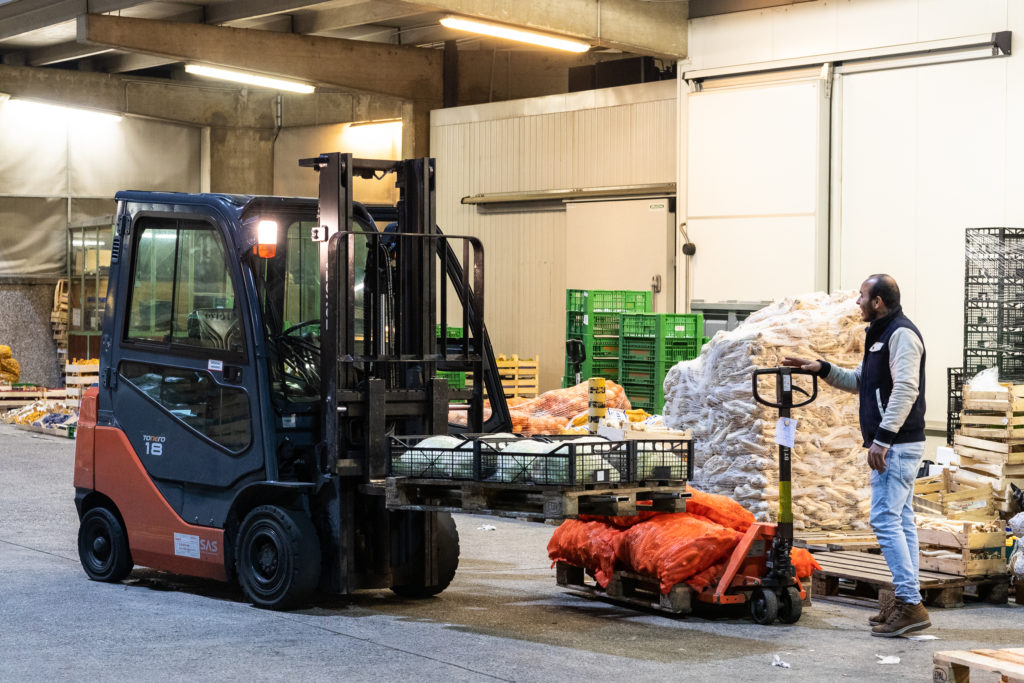 Gabelstapler und Gabelhubwagen beim Umladen von Waren