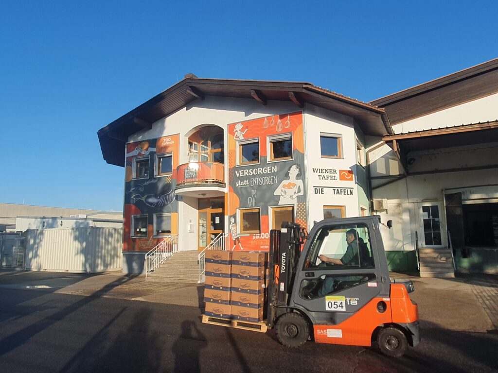 Gabelstapler vor einem Haus mit bemalter Fassade